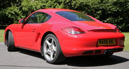 Red Porsche Cayman 2.9 PDK seen from the rear angle.