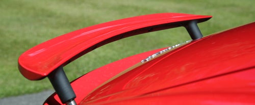 Close-up of Porsche Cayman's red rear spoiler.
