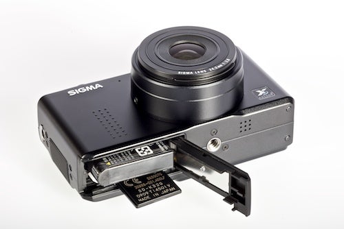 Sigma DP2 compact camera with open battery compartment.