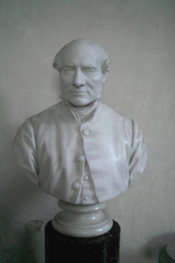 White bust of a male figure on a pedestal.