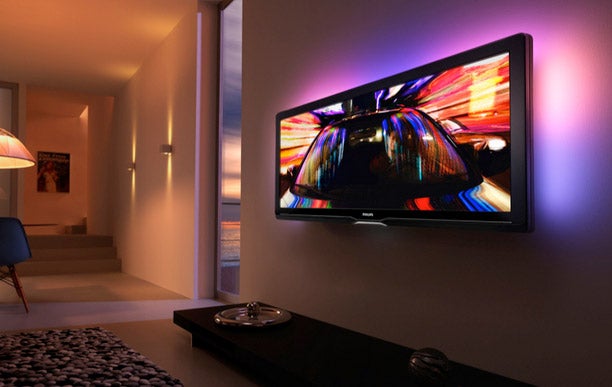 Philips Cinema 21:9 LCD TV displaying colorful image in living room.
