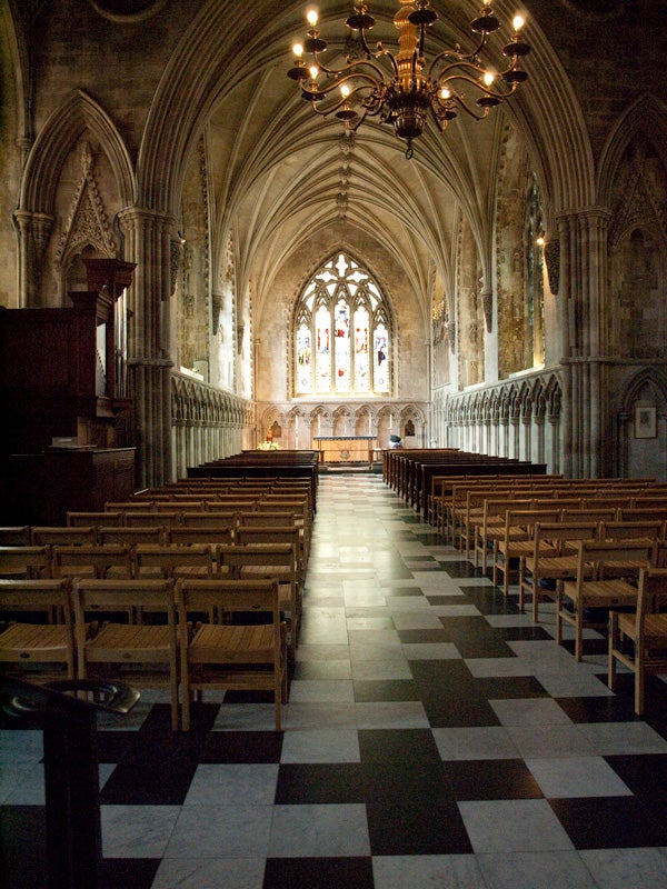Interior of a cathedral with vaulted ceilings and wooden pews.
