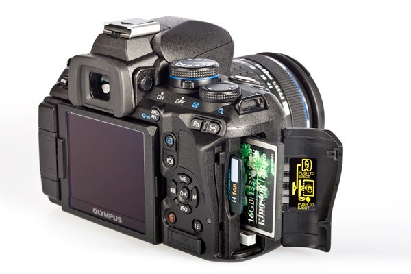 Olympus E-620 DSLR camera with open memory card slot.