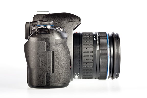 Olympus E-620 DSLR camera with lens on white background.