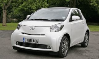 White Toyota iQ2 5MT compact car parked outdoors.
