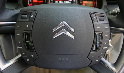 Close-up of Citroen C5 steering wheel controls and logo.