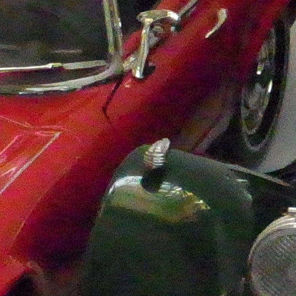 Close-up of a classic red car's bodywork taken with Ricoh CX1.