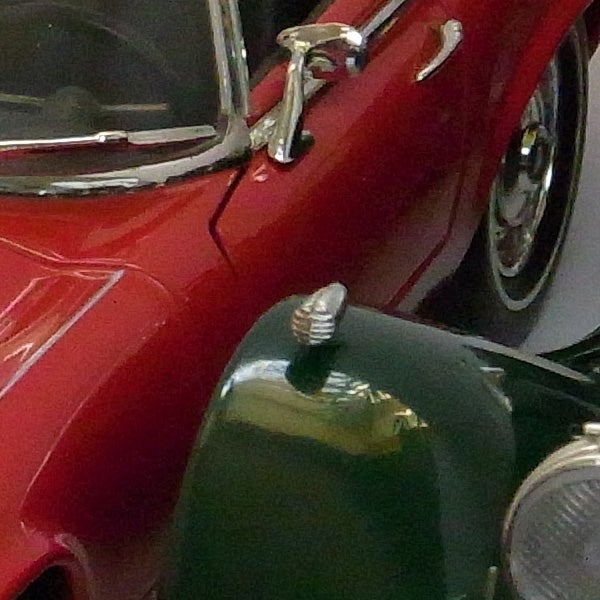 Close up of a red vintage car with chrome details.