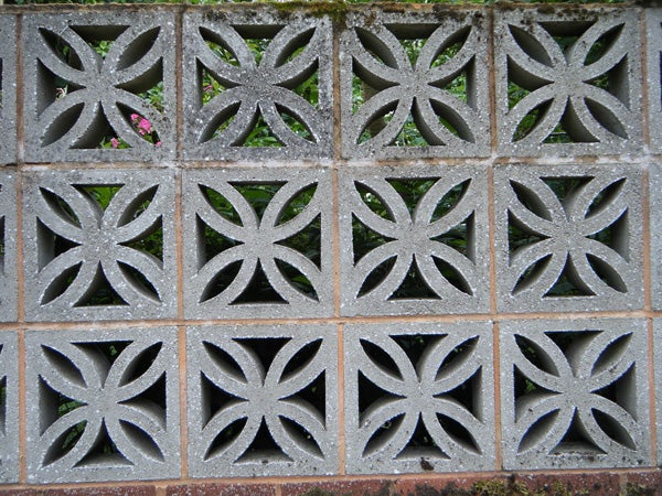 Decorative concrete block wall with a floral pattern.
