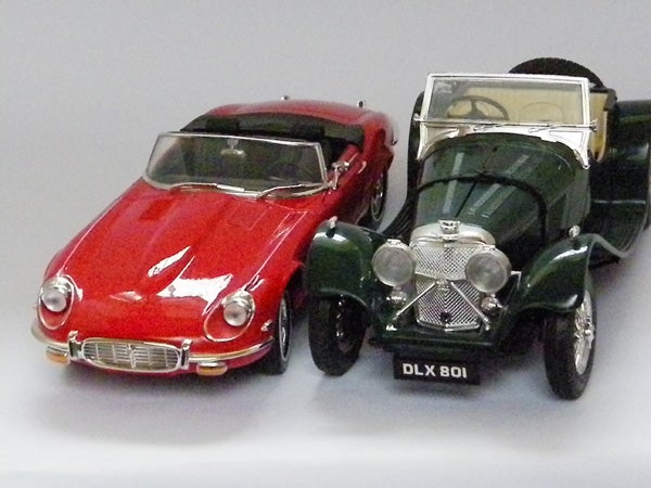 Model toy cars, one red and one green, photographed close up.