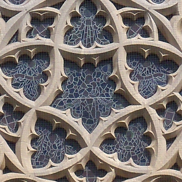Intricate stone facade with gothic patterns and stained glass.
