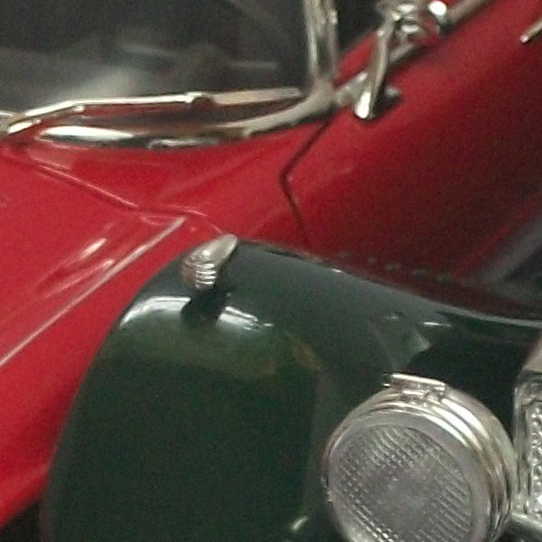 Close-up of a classic red and green toy cars.