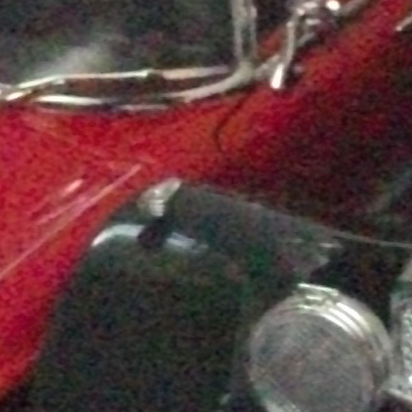Blurred image of reflective surfaces and red fabric.