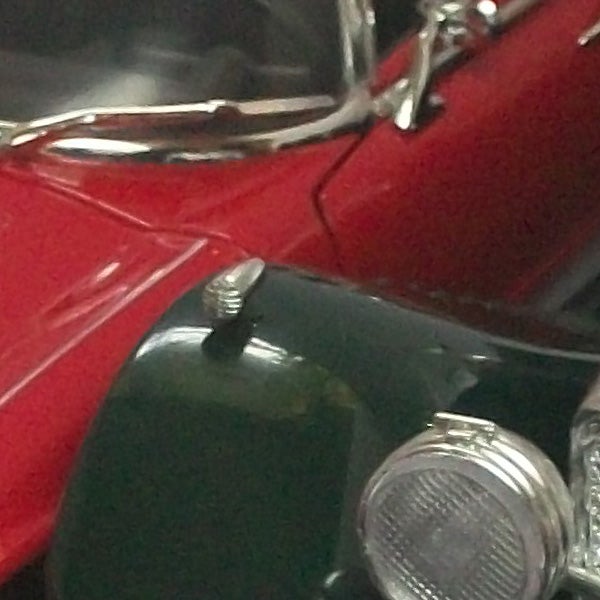 Close-up of a vintage red and green car's bodywork.