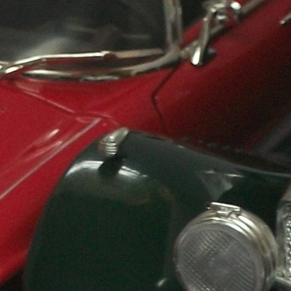Close-up of a red and green vintage car model.