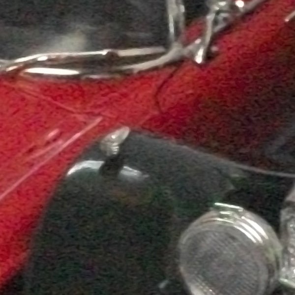 Blurred close-up image of metallic and red objects.