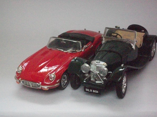 Toy model cars on display, red Jaguar and black vintage car.