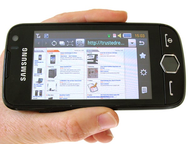 Hand holding a Samsung Jet S8000 displaying a web page.