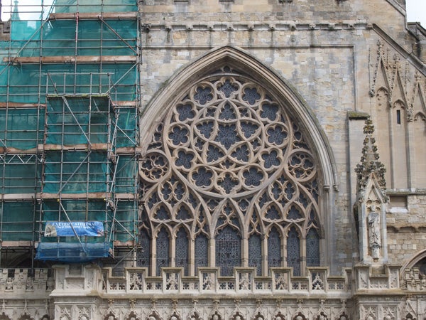 Ornate gothic church window with scaffolding on the left side.