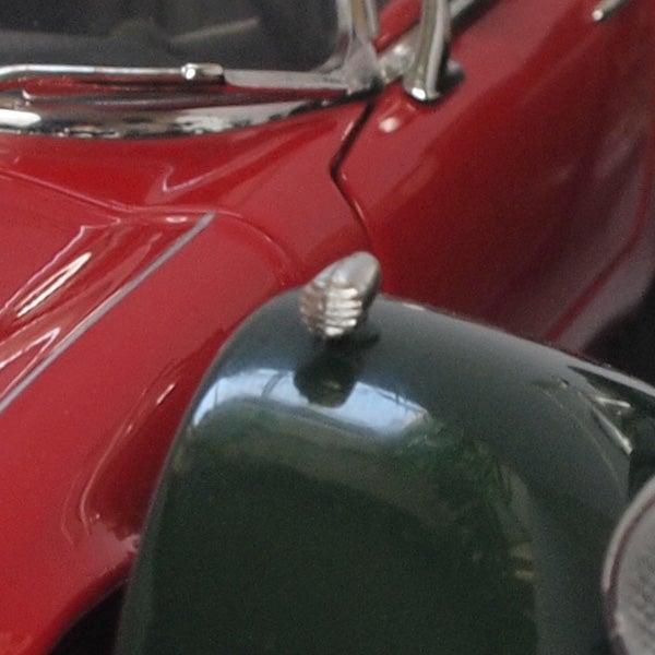 Close-up of a vintage car's red and green glossy finish.