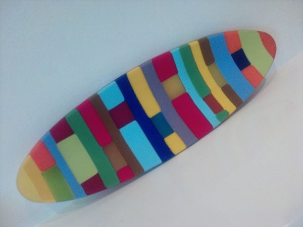 Colorful abstract surfboard-shaped artwork on white background.