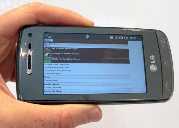 Hand holding LG Crystal GD900 phone displaying a web page.