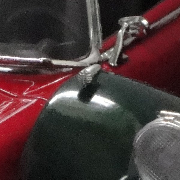 Close-up of a red and green toy car with chrome details.