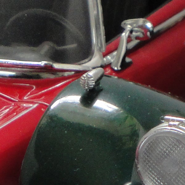Close-up photo of a red vintage car model.