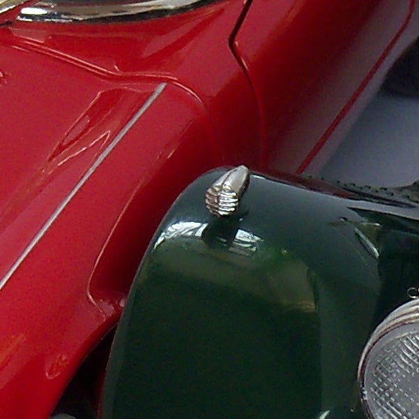 Close-up of a red and green toy motorcycle wheels and fender