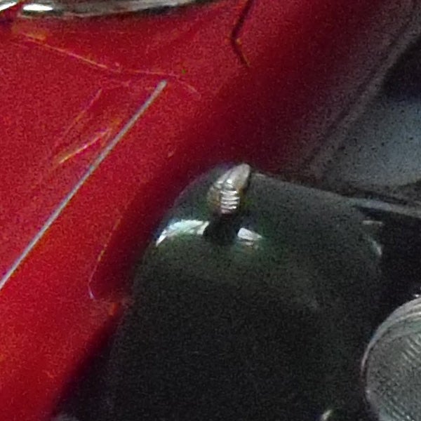 Close-up photo of a red surface with a screw.