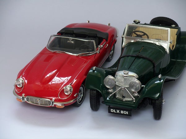 Red and green vintage toy cars on a white background.
