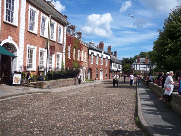 Cobbled street and historic buildings under clear skies.