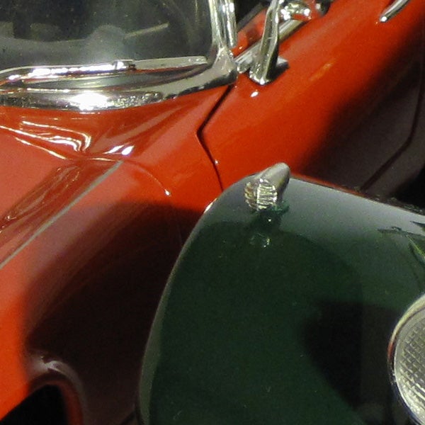 Close-up of a vintage car model in orange and green.