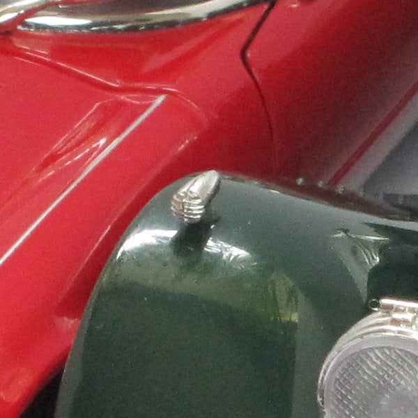 Close-up of a red and green vintage car front detail.