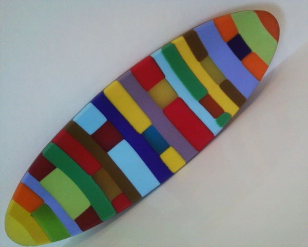 Colorful abstract mosaic surfboard-shaped artwork on white background