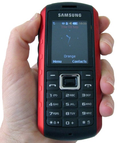 Hand holding a Samsung Solid Extreme B2100 phone.