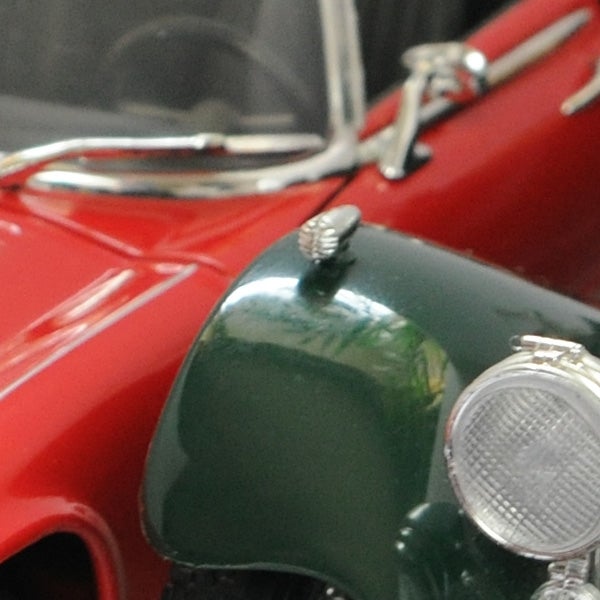 Close-up of a vintage toy car model in red and green.