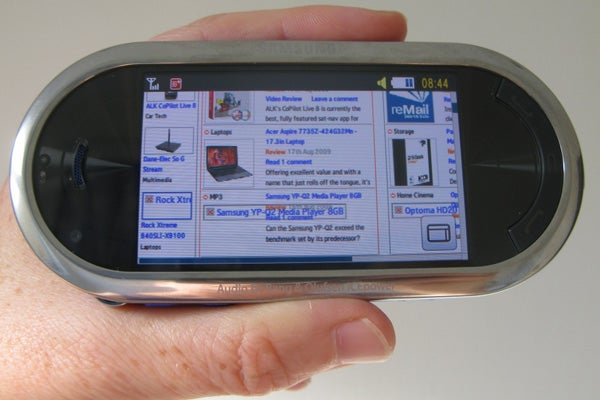 Samsung M7600 Beat DJ phone held in a hand displaying its screen.
