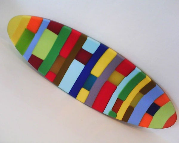 Colorful abstract art surfboard on white background.