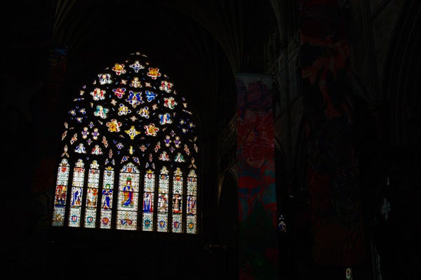 Stained glass window in dimly lit church interior