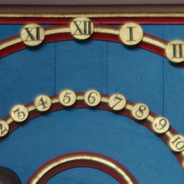 Close-up of clock face with Roman and Arabic numerals.