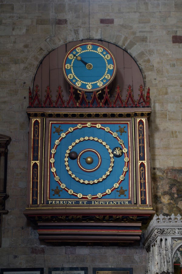Colorful astronomical clock in a historical building interior.