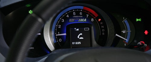 Honda Insight's dashboard with touchscreen and audio controlsHonda Insight dashboard focused on hybrid system indicator.