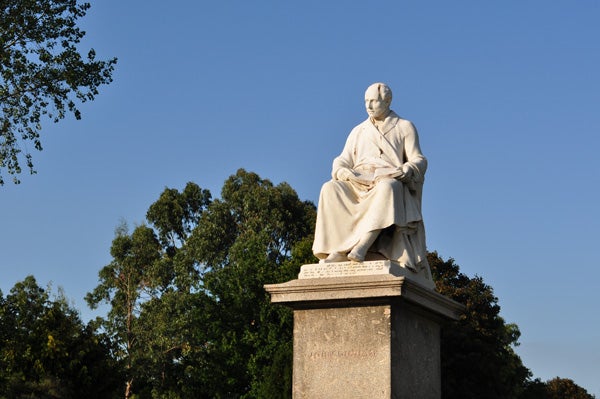 Marble statue of a historical figure in a park.