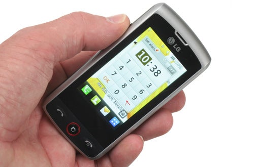 Hand holding LG GW520 mobile phone displaying home screen.