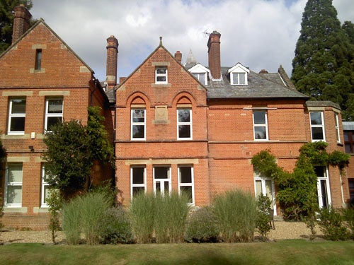 Photo of a red-brick Victorian house with chimneys