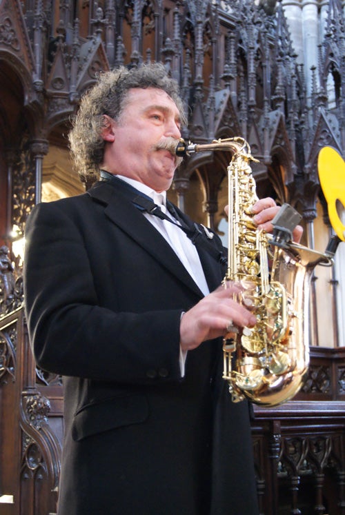 Man playing saxophone at a formal event.