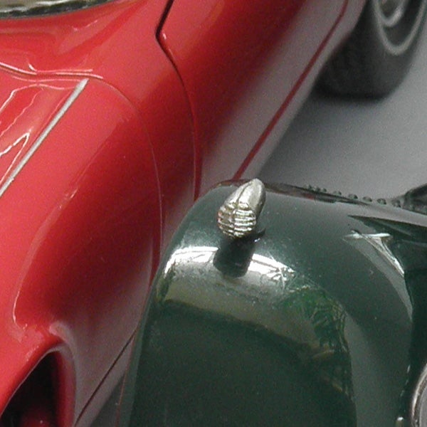 Close-up of a silver screw on a green and red toy car.