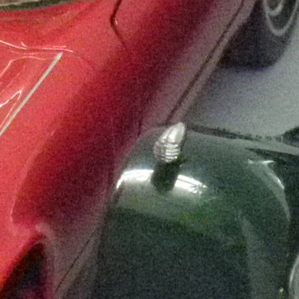 Silver screw on green and red car hoods.