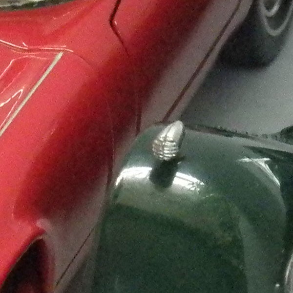 Close-up of a toy car's antenna and roof.